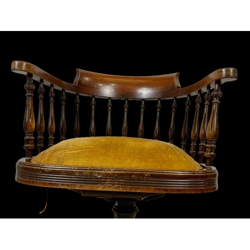 874 - An Edwardian mahogany ship’s captains chair stamped Arch Stewart & Co. with a cast iron base.