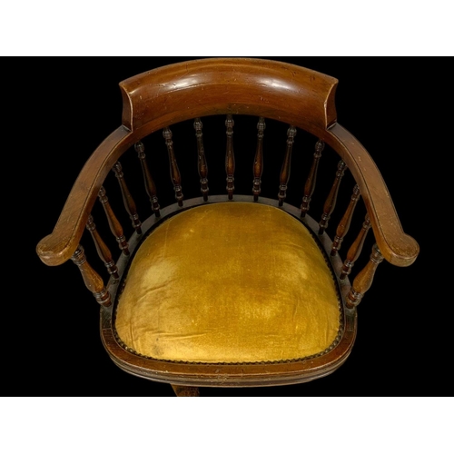 874 - An Edwardian mahogany ship’s captains chair stamped Arch Stewart & Co. with a cast iron base.