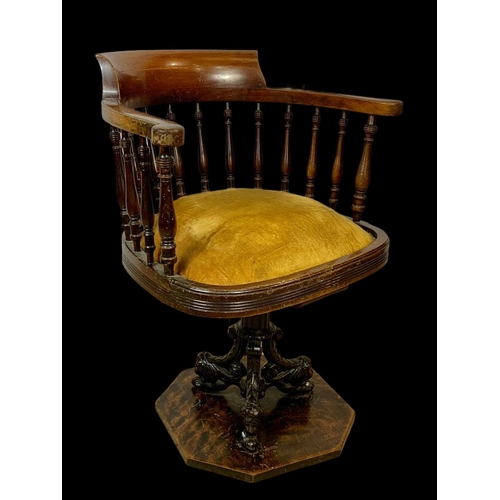 874 - An Edwardian mahogany ship’s captains chair stamped Arch Stewart & Co. with a cast iron base.