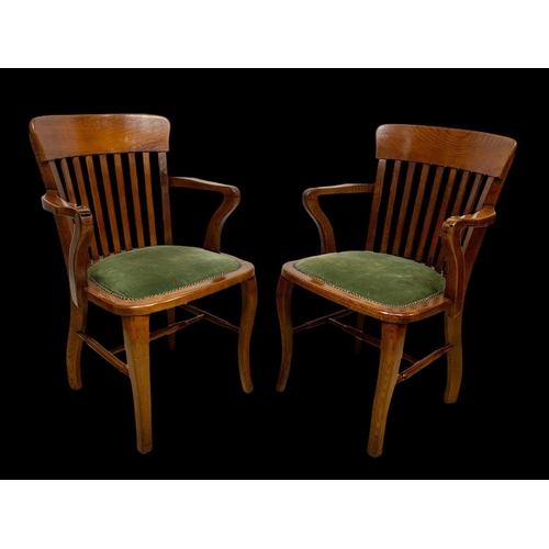 886 - A pair of Edwardian oak desk armchairs.