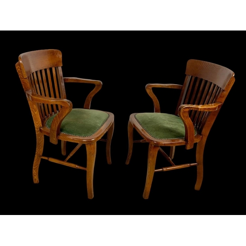 886 - A pair of Edwardian oak desk armchairs.