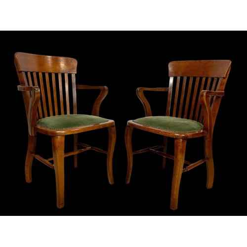 886 - A pair of Edwardian oak desk armchairs.