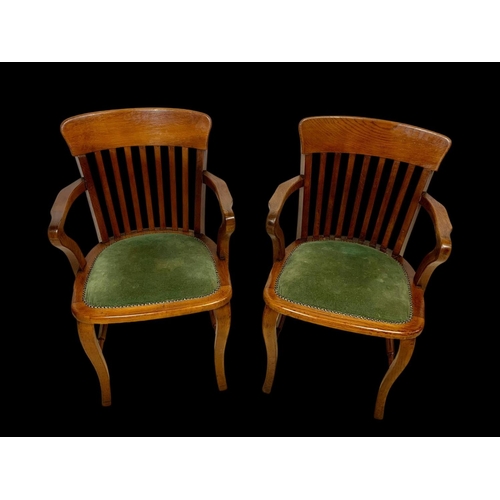 886 - A pair of Edwardian oak desk armchairs.