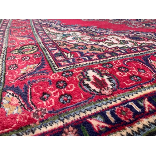 913 - A large vintage Middle Eastern hand knotted rug. 291 x 309cm