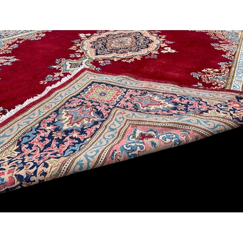 918 - A large vintage Middle Eastern hand knotted rug. 311.5 x 405cm.