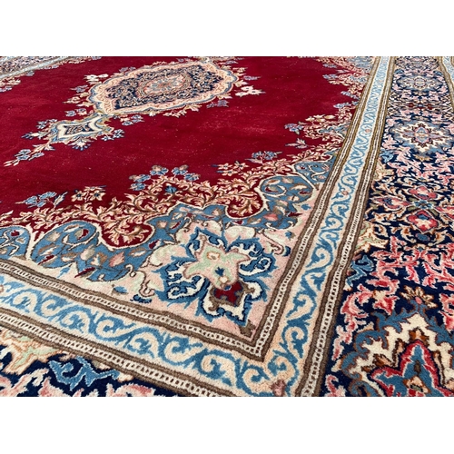 918 - A large vintage Middle Eastern hand knotted rug. 311.5 x 405cm.