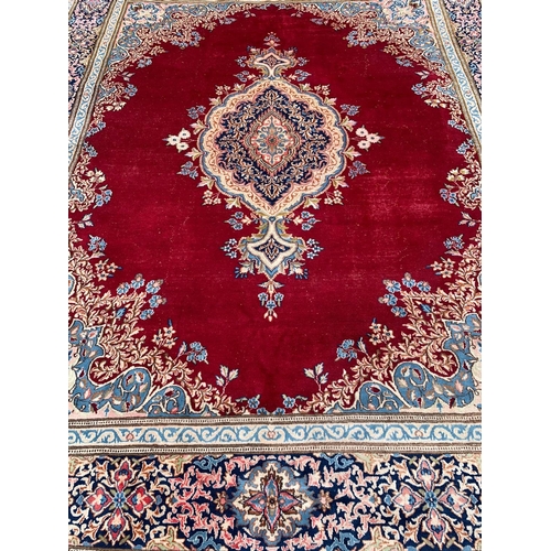 918 - A large vintage Middle Eastern hand knotted rug. 311.5 x 405cm.