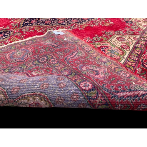 919 - A large vintage Middle Eastern hand knotted rug. 304 x 394cm.