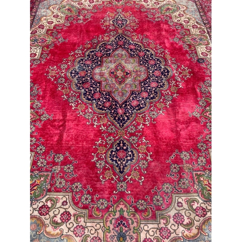 919 - A large vintage Middle Eastern hand knotted rug. 304 x 394cm.