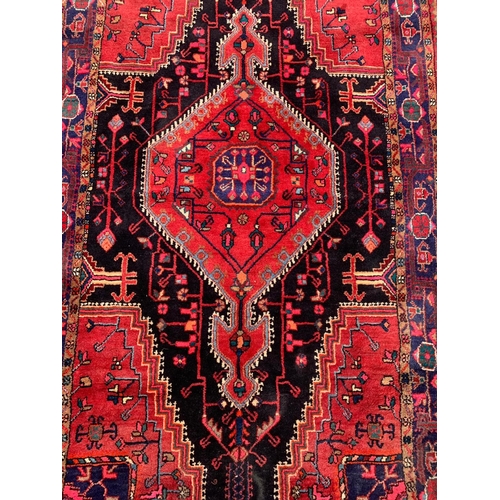 921 - A large vintage Middle Eastern hand knotted rug 141 x 247cm.