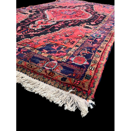 921 - A large vintage Middle Eastern hand knotted rug 141 x 247cm.