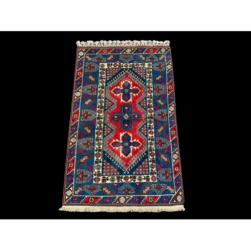 922 - A vintage Middle Eastern hand knotted rug. 123 x 205cm