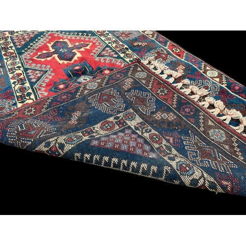 922 - A vintage Middle Eastern hand knotted rug. 123 x 205cm