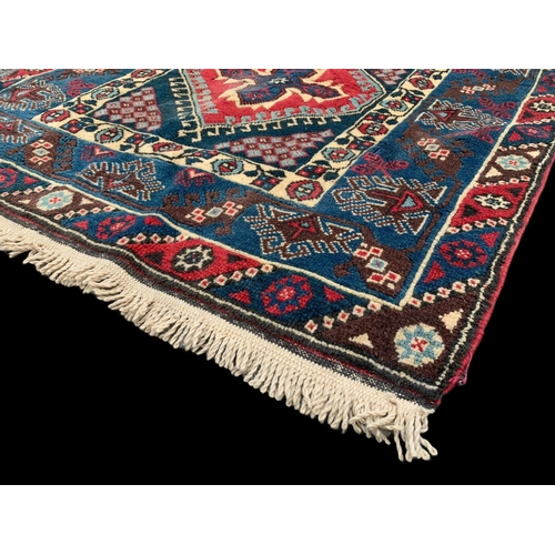 922 - A vintage Middle Eastern hand knotted rug. 123 x 205cm