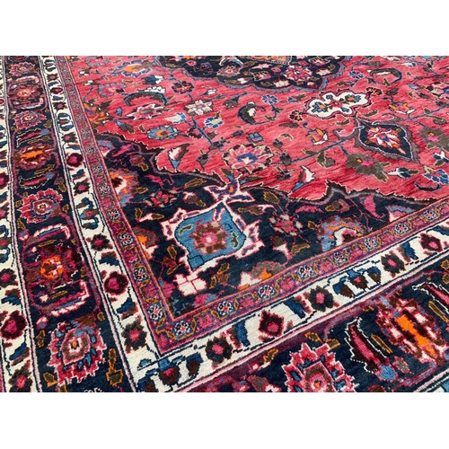 927 - A large vintage Middle Eastern hand knotted rug. 293 x 383cm.