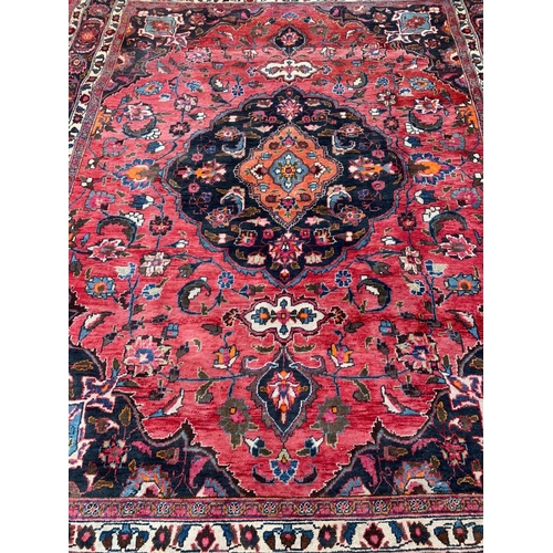 927 - A large vintage Middle Eastern hand knotted rug. 293 x 383cm.