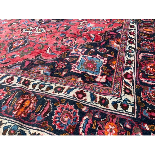 927 - A large vintage Middle Eastern hand knotted rug. 293 x 383cm.