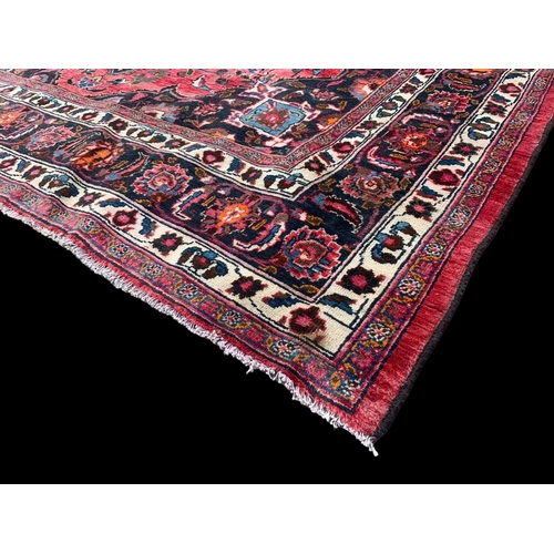 927 - A large vintage Middle Eastern hand knotted rug. 293 x 383cm.