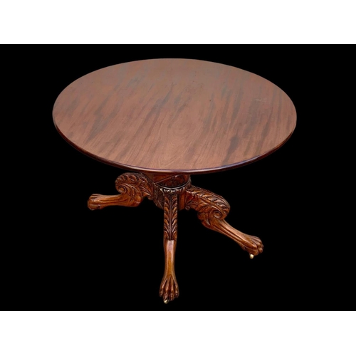 961 - An early 19th century William IV mahogany centre table with ornately carved base on lion paw feet an... 