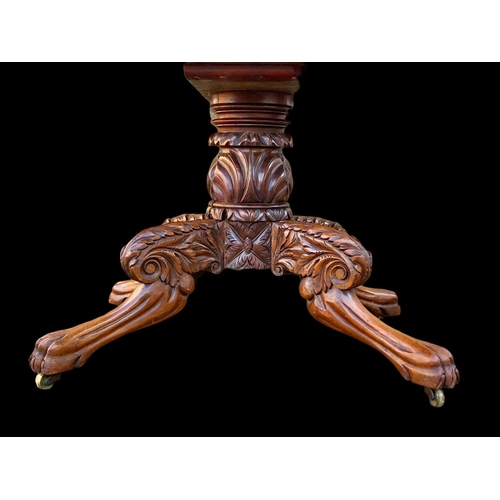 961 - An early 19th century William IV mahogany centre table with ornately carved base on lion paw feet an... 