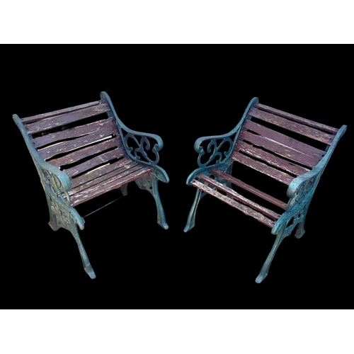 974 - A pair of cast iron garden armchairs.