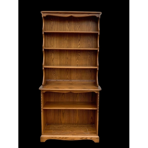 1023 - An Ercol elm shelving unit. 93 x 37 x 192cm.