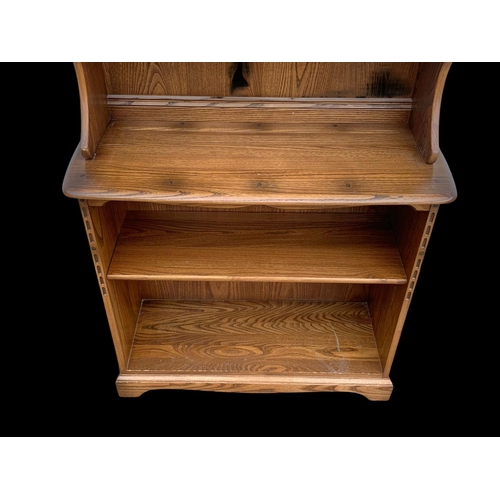 1023 - An Ercol elm shelving unit. 93 x 37 x 192cm.