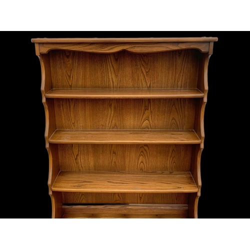 1023 - An Ercol elm shelving unit. 93 x 37 x 192cm.