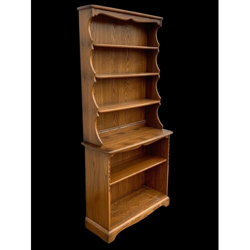 1023 - An Ercol elm shelving unit. 93 x 37 x 192cm.