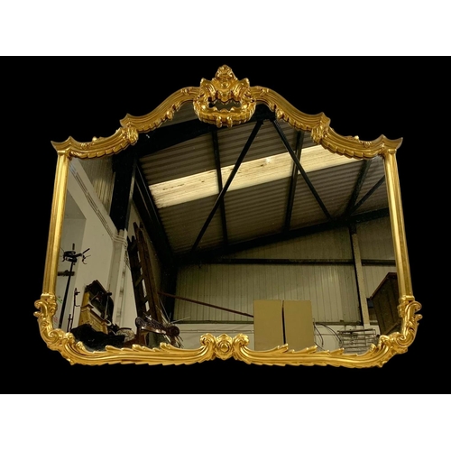 213 - A large ornate gilt framed mirror. 120 x 103.5cm.