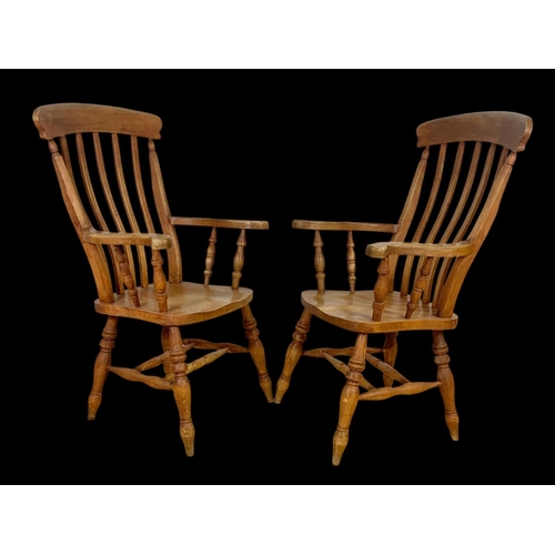 890 - A pair of Victorian style beech farmhouse high back armchairs. 114.5cm ground to back