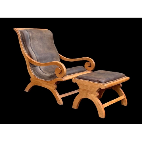 902 - A large colonial style maple and leather armchair with matching stool. 66.5 x 91 x 105cm.