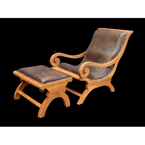 902 - A large colonial style maple and leather armchair with matching stool. 66.5 x 91 x 105cm.