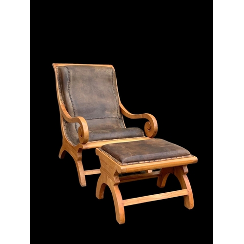 902 - A large colonial style maple and leather armchair with matching stool. 66.5 x 91 x 105cm.