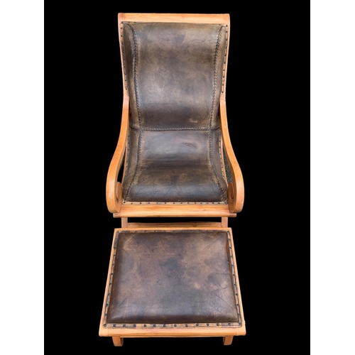 902 - A large colonial style maple and leather armchair with matching stool. 66.5 x 91 x 105cm.