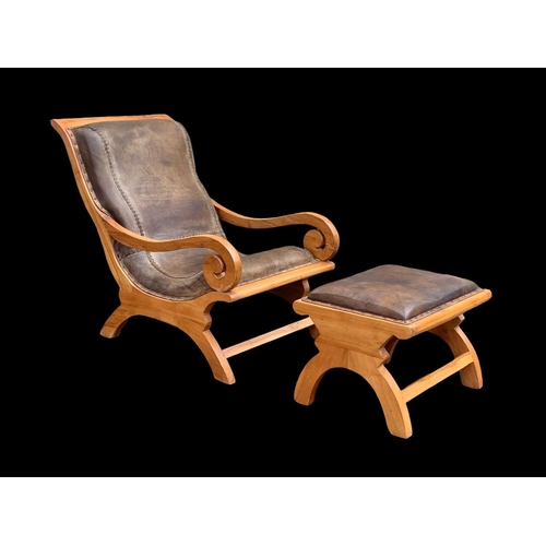 903 - A large colonial style maple and leather armchair with matching stool. 66.5 x 91 x 105cm