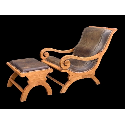 903 - A large colonial style maple and leather armchair with matching stool. 66.5 x 91 x 105cm