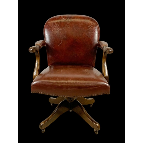 945 - An early 20th century mahogany and leather swivel desk chair. Circa 1920. 65 x 60 x 92cm.