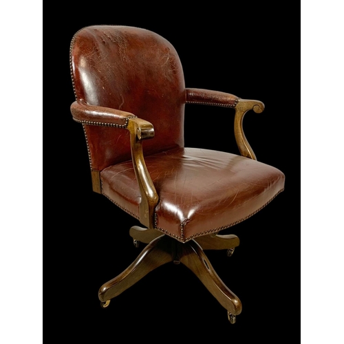 945 - An early 20th century mahogany and leather swivel desk chair. Circa 1920. 65 x 60 x 92cm.