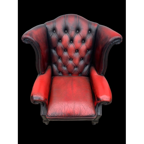 959 - A deep button Ox-Blood leather wingback armchair.