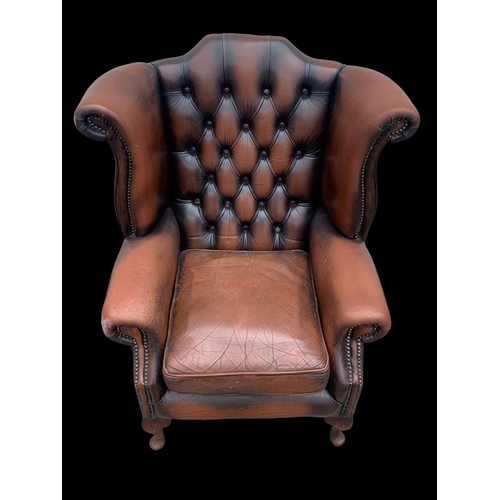 960 - A large deep button leather wingback armchair.