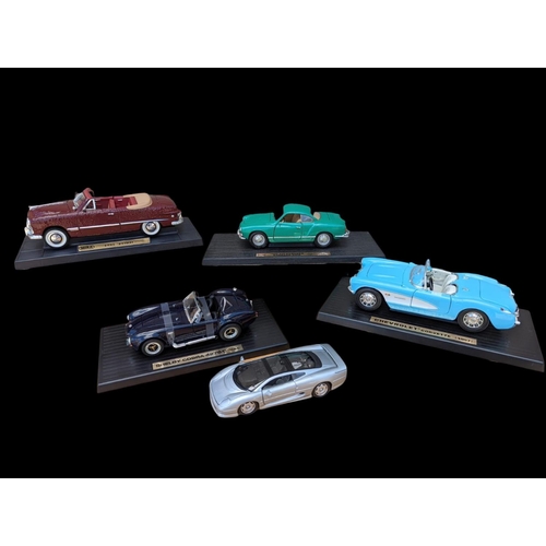 236 - 5 model cars on stands, largest stand measures 35cm