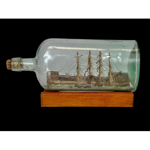 577 - A Bushmills Malt whiskey water jug and a ship in a bottle. Bottle measures 28cm.