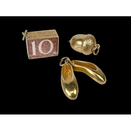 683 - 3 9ct gold charms. 7.55 grams.