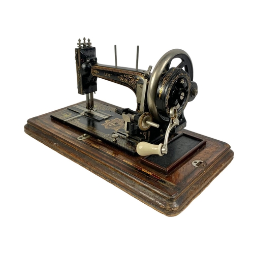 340d - A late Victorian hand turning sewing machine in an inlaid case. With Leo The Lion. Circa 1890/1900. ... 