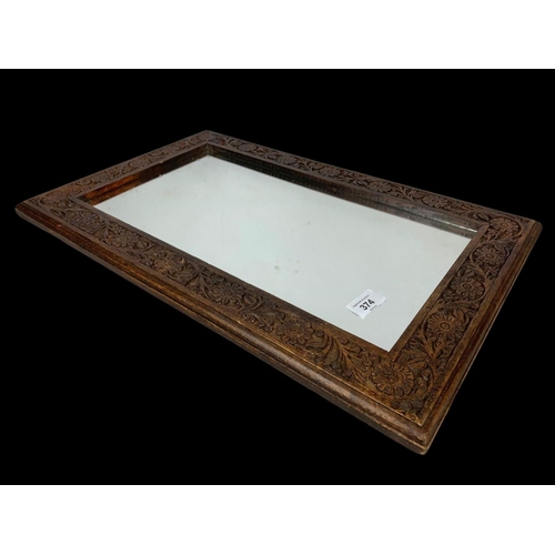 374 - A carved oak framed mirror. 35.5 x 55.5cm.