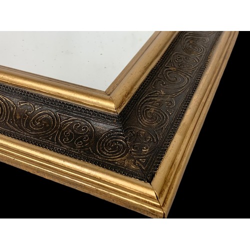 728 - An ornate gilt framed mirror.  51x58cm