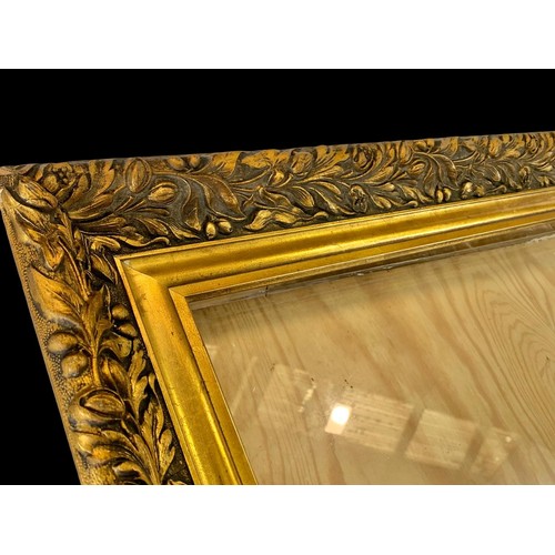 306f - A large vintage ornate gilt frame with glass. 114 x 84cm.