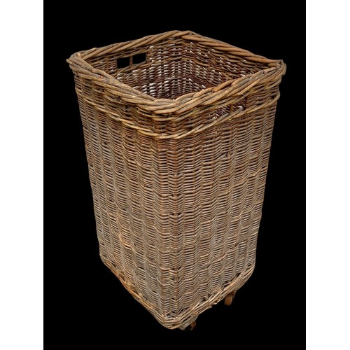 771 - A tall vintage wicker basket on wheels. 38 x 38 x 72cm.