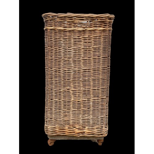 771 - A tall vintage wicker basket on wheels. 38 x 38 x 72cm.